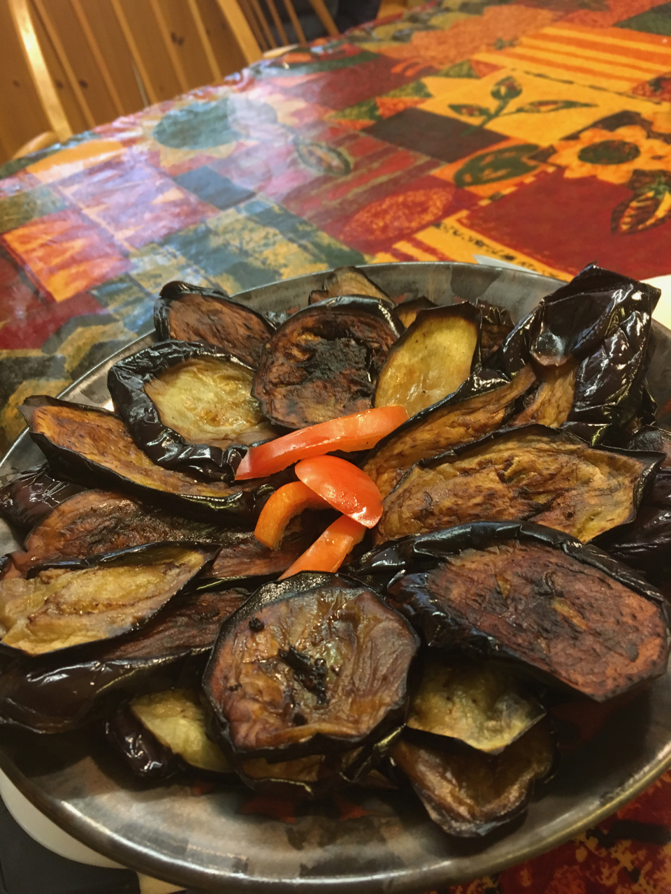 Slices of fried aubergine (babinjan) laid out on a dish.