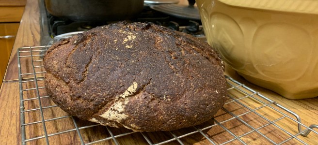 A loaf of bread on a cooler with a mixing bowl in the background